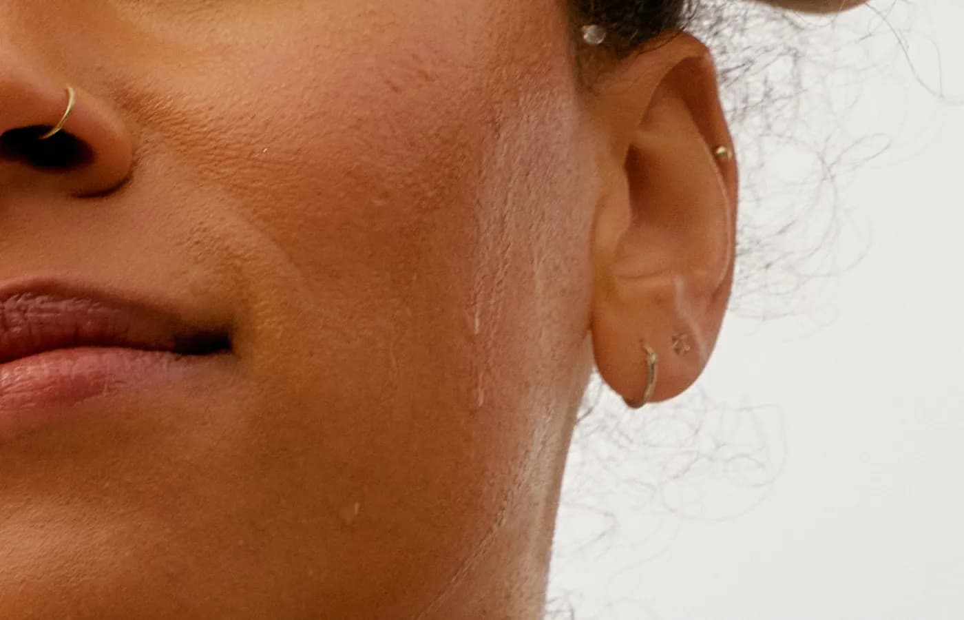 A close portrait of a woman’s jaw and neck, skin still damp after training.